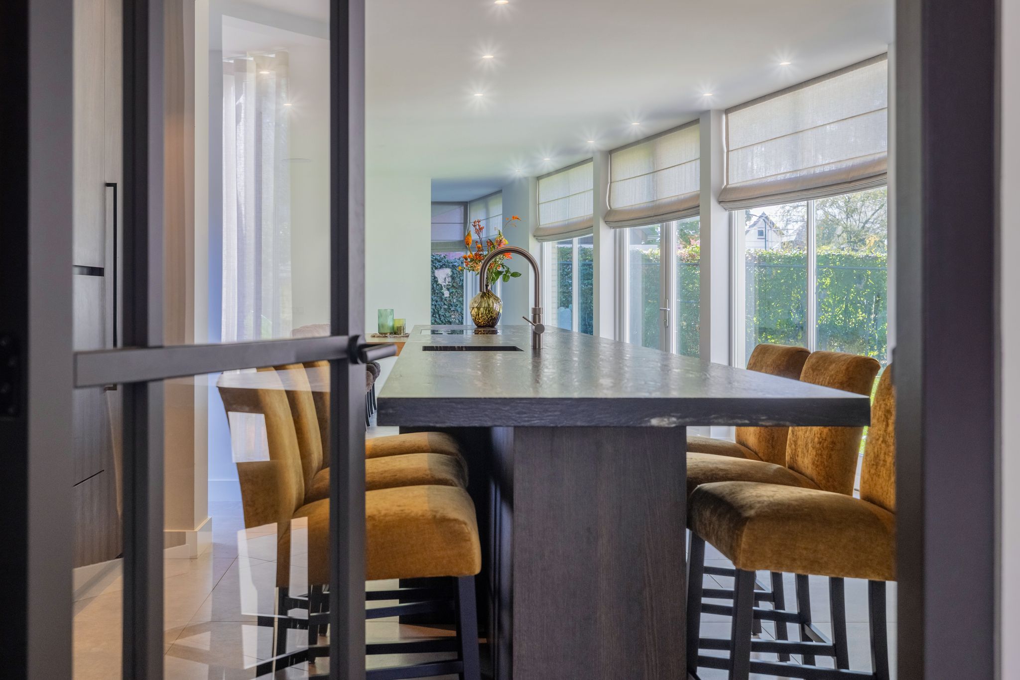 zicht-vanuit-hal-op-leefkeuken-met-barstoelen-en-werkblad.jpg
